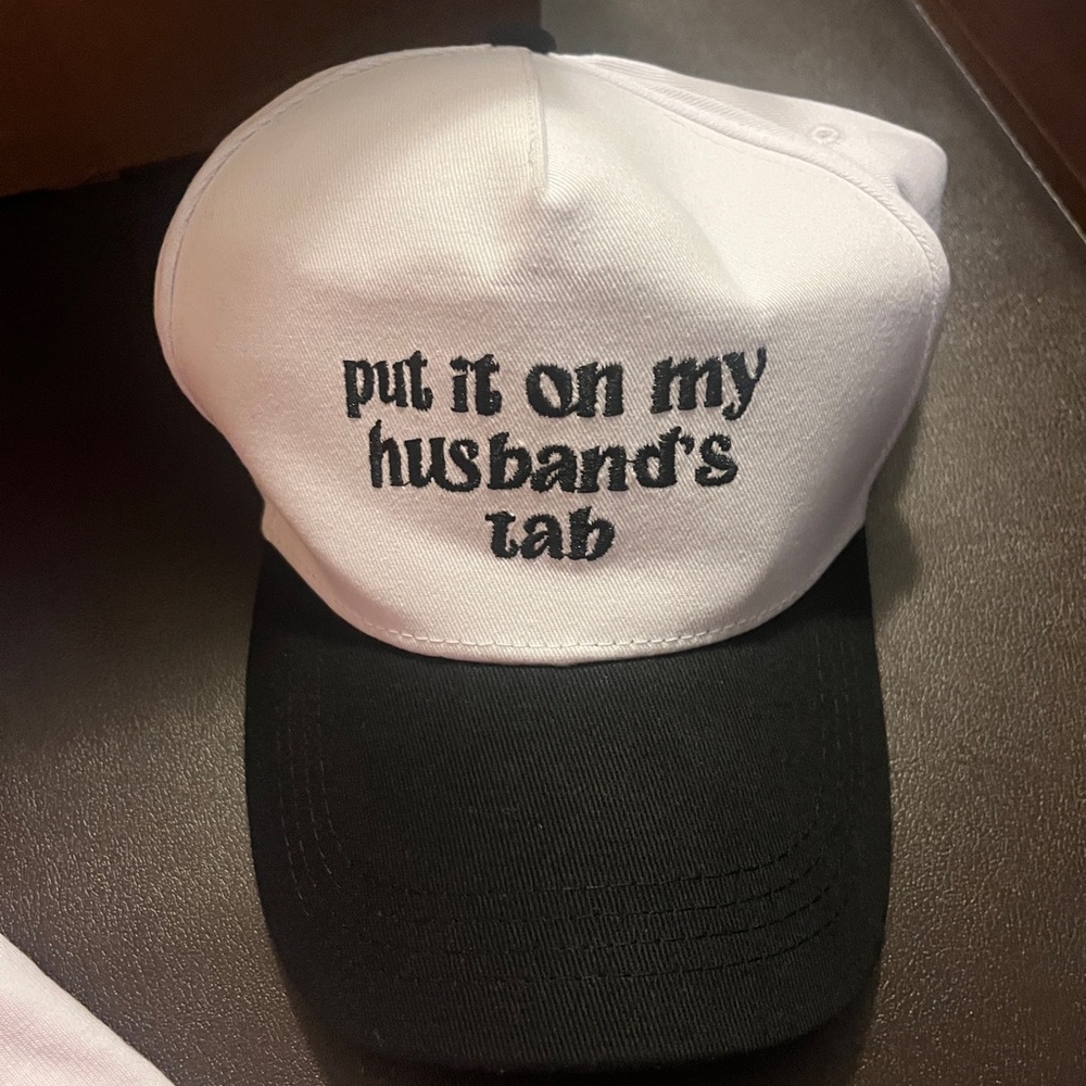 Put It On My Husband’s Tab” White and Black Cap with Embroidered Text